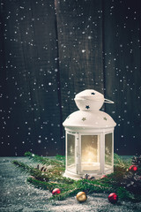 Burning Candle Lantern and Christmas composition of spruce branches and balls