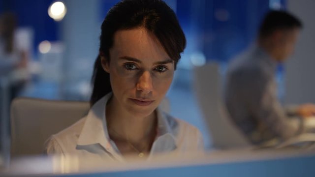  Business team working late. Man & woman discussing information on computer