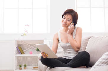 Smiling young girl using phone and tablet