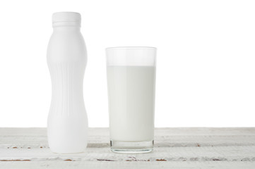 Milk glass and bottle on white background