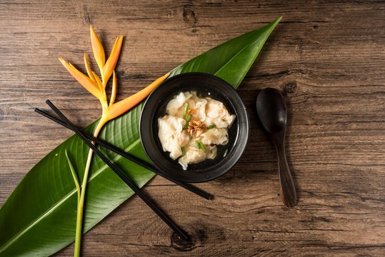 Shrimp wonton with braised pork in soup on wooden table - Asian food style  / Select focus image