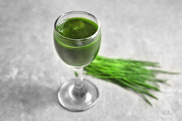 Shot of healthy wheat grass juice on table