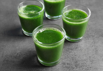 Shots of healthy wheat grass juice on grey background