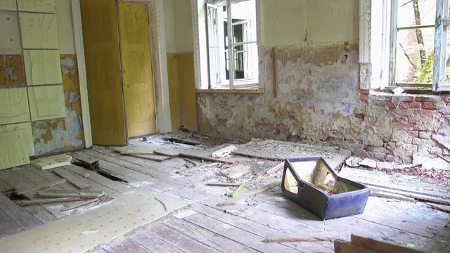 Chernobyl, Ukraine - 17th of June 2017: Visit to Zalesye village in Chernobyl zone - 4K Lost pram on the floor of the cultural center