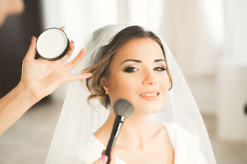 Makeup artist preparing bride to the wedding
