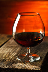 Glass of brandy or cognac on the wooden table.