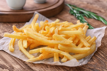 Yummy french fries on wooden table