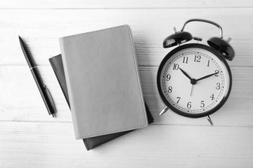 Time management concept. Composition with alarm clock on wooden table