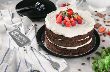 Delicious chocolate cake with berries on table