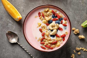 Tasty breakfast with goji berries in bowl on table