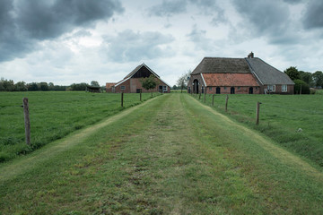 Fototapeta na wymiar Old farm in countryside under dark stormy sky