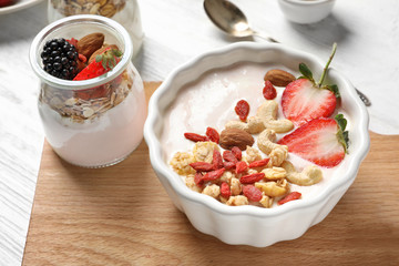 Tasty breakfast with goji berries on wooden board