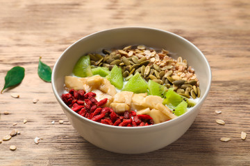 Tasty breakfast with goji berries in bowl on table