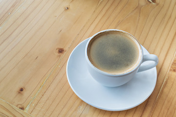 Coffee cup on a wooden table, selective focus (detailed close-up shot)