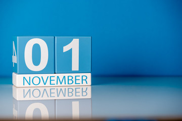 November 1st. Day 1 of last autumn month, calendar on blue background. Empty space for text