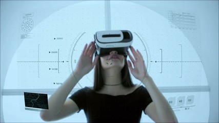 Young attractive Asian female uses futuristic virtual reality headset to access holographic touchscreen interface - Powered by Adobe