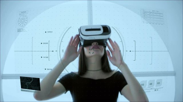 Young attractive Asian female uses futuristic virtual reality headset to access holographic touchscreen interface