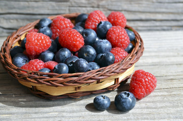 Fresh organic blueberries and raspberries.
Freshly picked raspberries and blueberries in a basket on a burlap cloth background.Blueberry and raspberry.Healthy eating,diet concept.Selective focus.