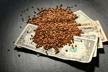 Raw buckwheat and money on table. Price growth concept