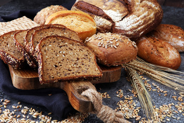 Sliced rye bread on cutting board. Whole grain rye bread and rolls with seeds.