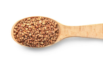 Raw buckwheat in wooden spoon on white background