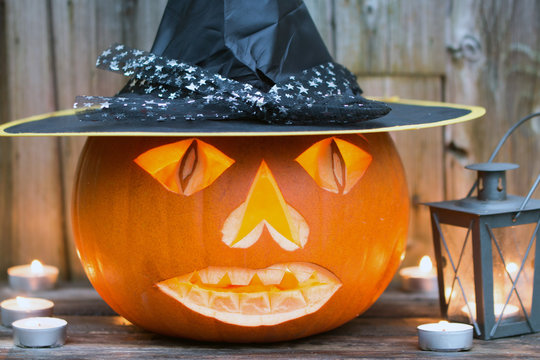 Gruseliger Halloween Kürbis mit Hut und Laterne als Dekoration für den 31. Oktober
