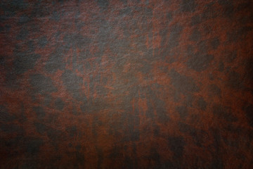Black and brown  spotted texture of leather with vignette.