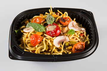 Noodles with pork and vegetables in take-out box to go