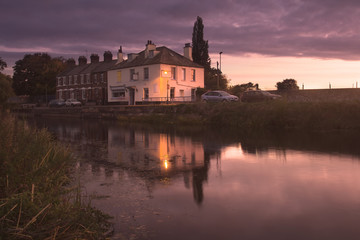 Houses on the banks of the channel of the river Exe. Evening. Sunset. Exeter. Devon. UK