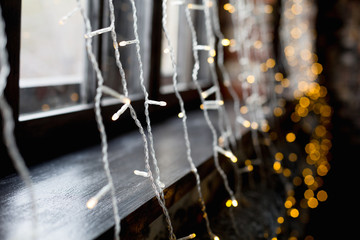 Christmas garlands for window decoration. Blurred shine background of Xmas. New Year mood. Selective focus.