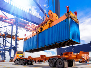 Industrial port crane lift up loading export containers box onboard from truck at port of...