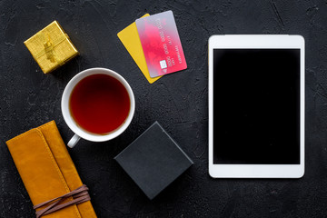 online payment for christmas present with credit card and tablet on black table background top view mockup