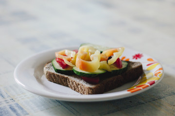 Vegetarian sandwich on white plate with floral pattern