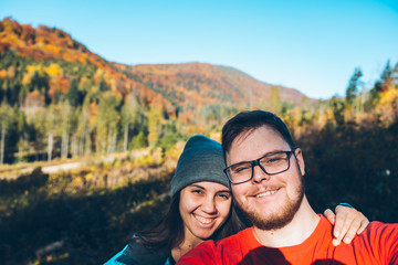 Couple taking self portrait in mountains with smartphone