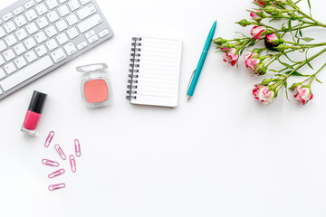 woman desk design with cosmetics, petals and notebook white background top view mock-up