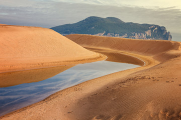 Mantilla river flows into the sea between dunes in Laredo, Cantabria, Spain