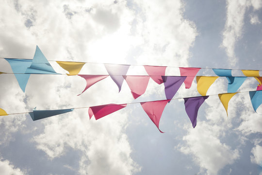 Colorful Triangle Banner Flags Waving in the Wind with Cloud Background
