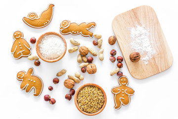 Healthy food for sportsman. Cookies in shape of yoga asanas near nuts on white background top view