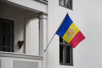Andorra flag. Andorran flag displaying on a pole in front of the house. National flag of  Andorra waving on a home hanging from a pole on a front door of a building.