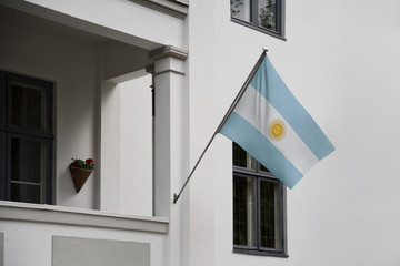 Argentina flag.  Argentinian flag displaying on a pole in front of the house. National flag of  Argentina waving on a home hanging from a pole on a front door of a building. - 177980475
