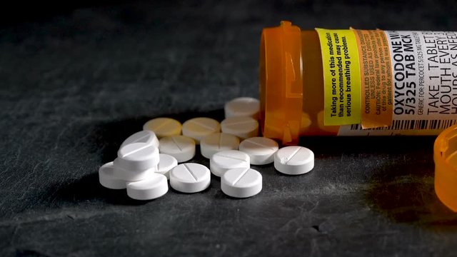 Macro video of Oxycodone Opioid tablets on slate table