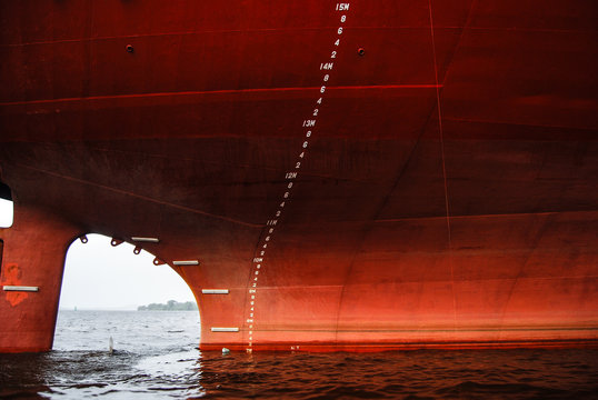 Prow of an old red freighter at wharf