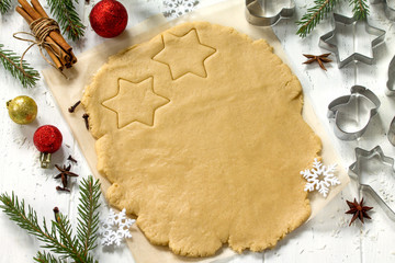 Christmas cookies. Ginger dough for gingerbread, star, Christmas tree, spices (cinnamon, cloves and anise), flour in the home kitchen white wooden table.