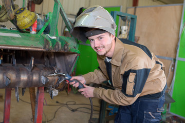 happy apprentice welder at work in the plant