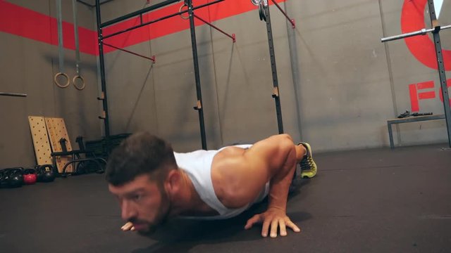 Man doing push-ups exercise at cross fitness training gym