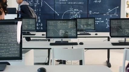 Adult student group arriving for class, math formulas on blackboard - Powered by Adobe