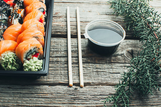 on a wooden table lay in the black sushi container