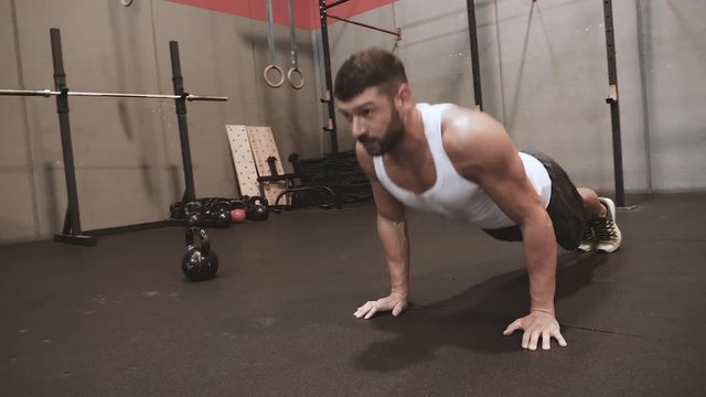 Man doing push-ups exercise at crossfit gym in slow motion 