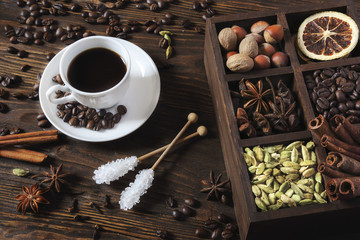 Black coffee in a white cup and various spices