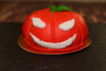Cake on Halloween  pumpkin. The idea for baking and decorating for Halloween. An ominous orange...
